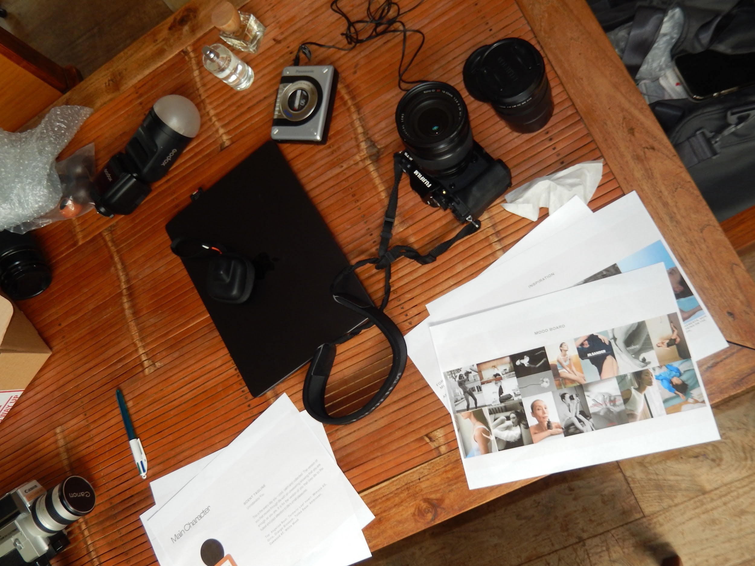 Camera equipment and prints on a wooden table