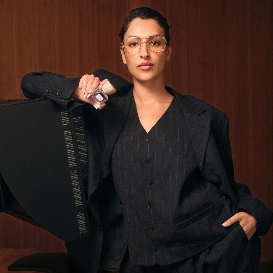 Model in a black suit holding a bottle of 'Power House' in front of a wooden background