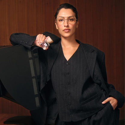 Model in a black suit holding a bottle of 'Power House' in front of a wooden background