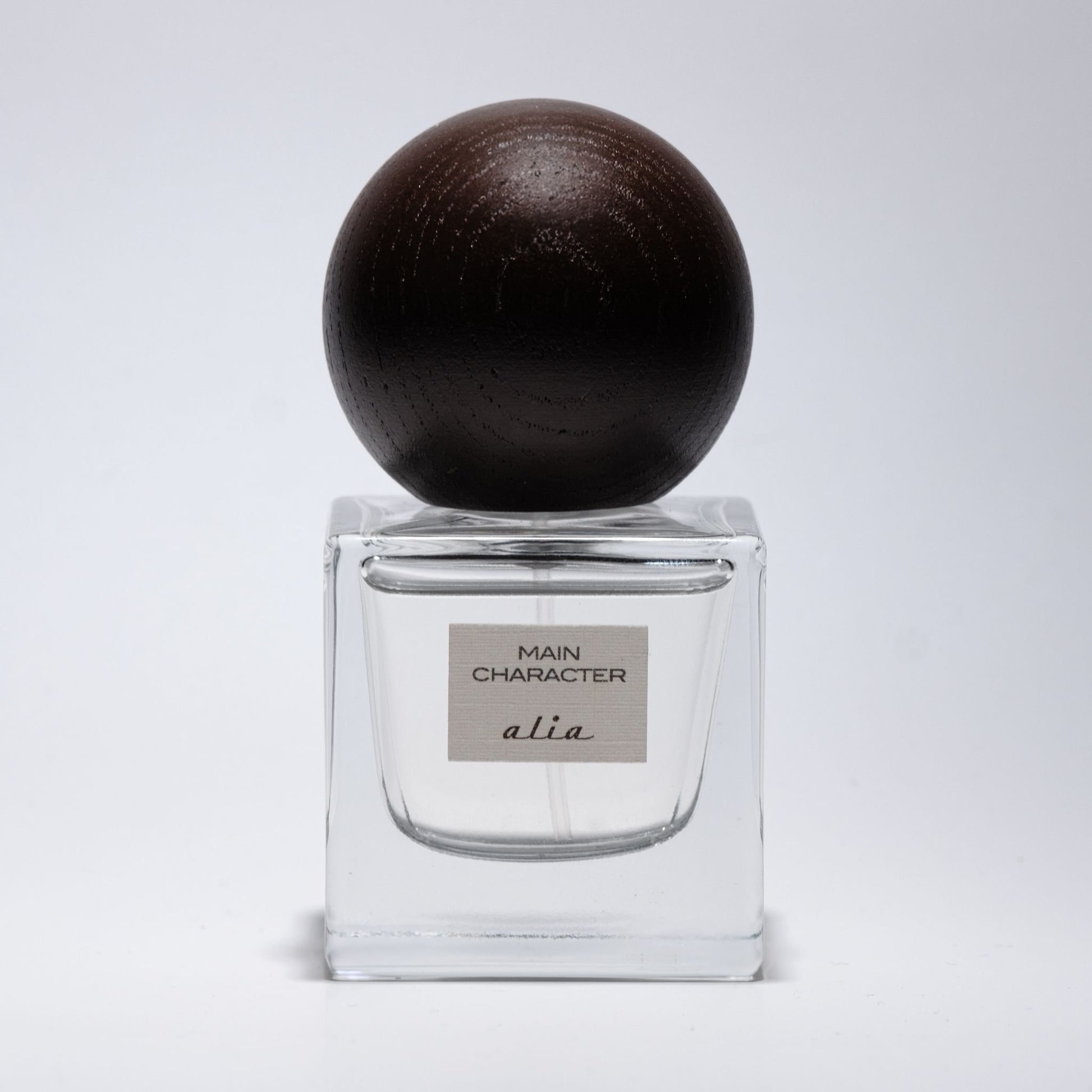 Perfume bottle with a dark brown cap on a light gray background