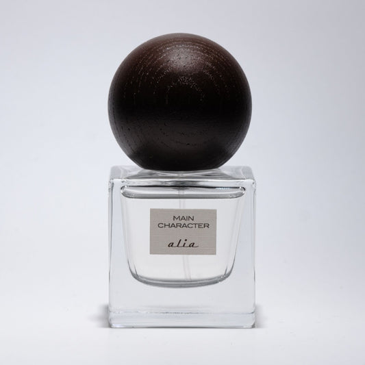 Perfume bottle with a dark brown cap on a light gray background