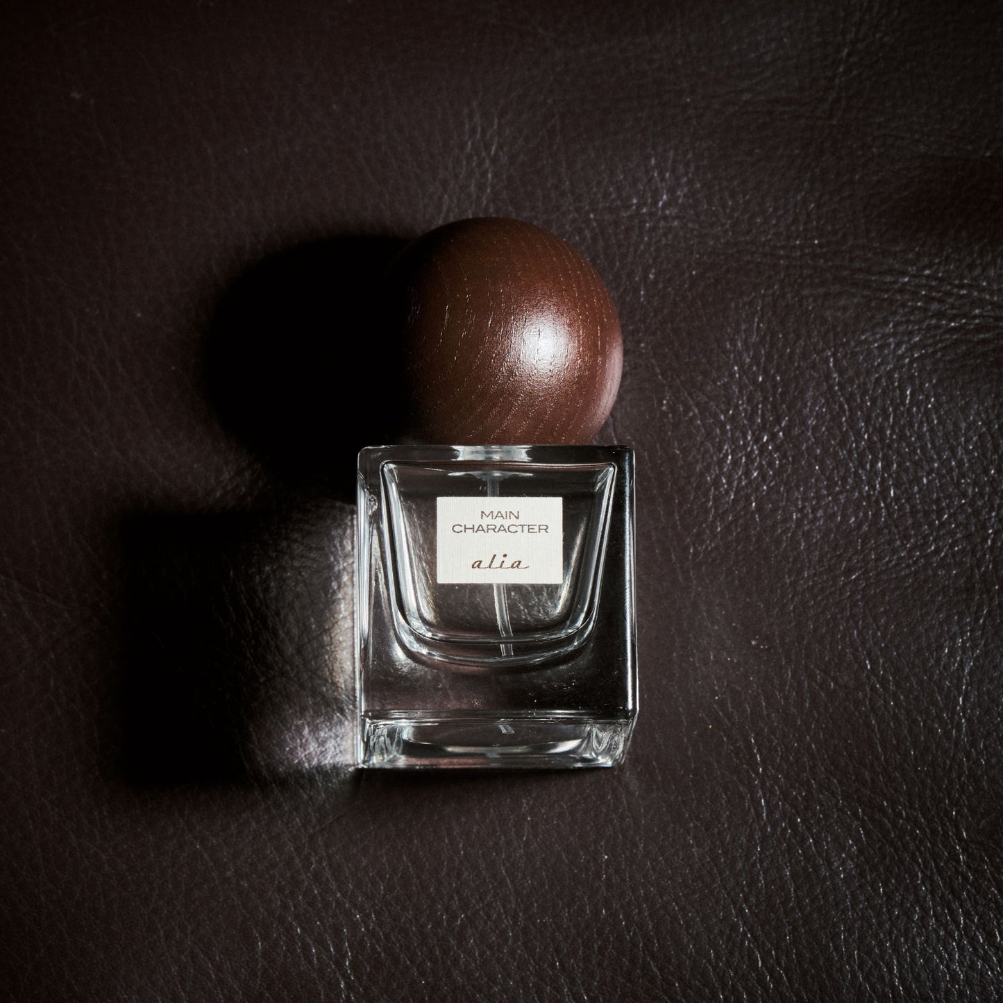 Alia Main Character perfume on black leather background