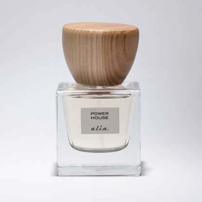 Clear perfume bottle with wooden cap on a light gray background