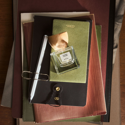 'Power House' perfume bottle on a stack of books 