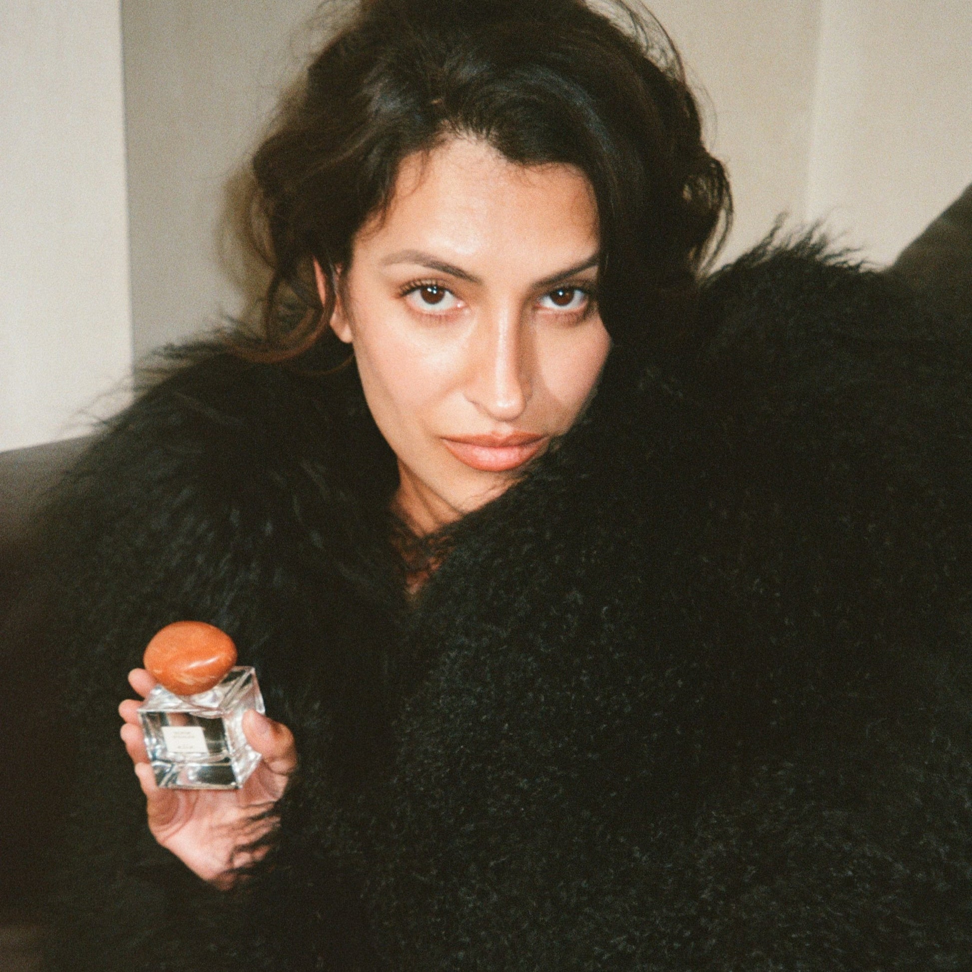 Model holding a bottle of 'Scene Stealer' with a blurred background