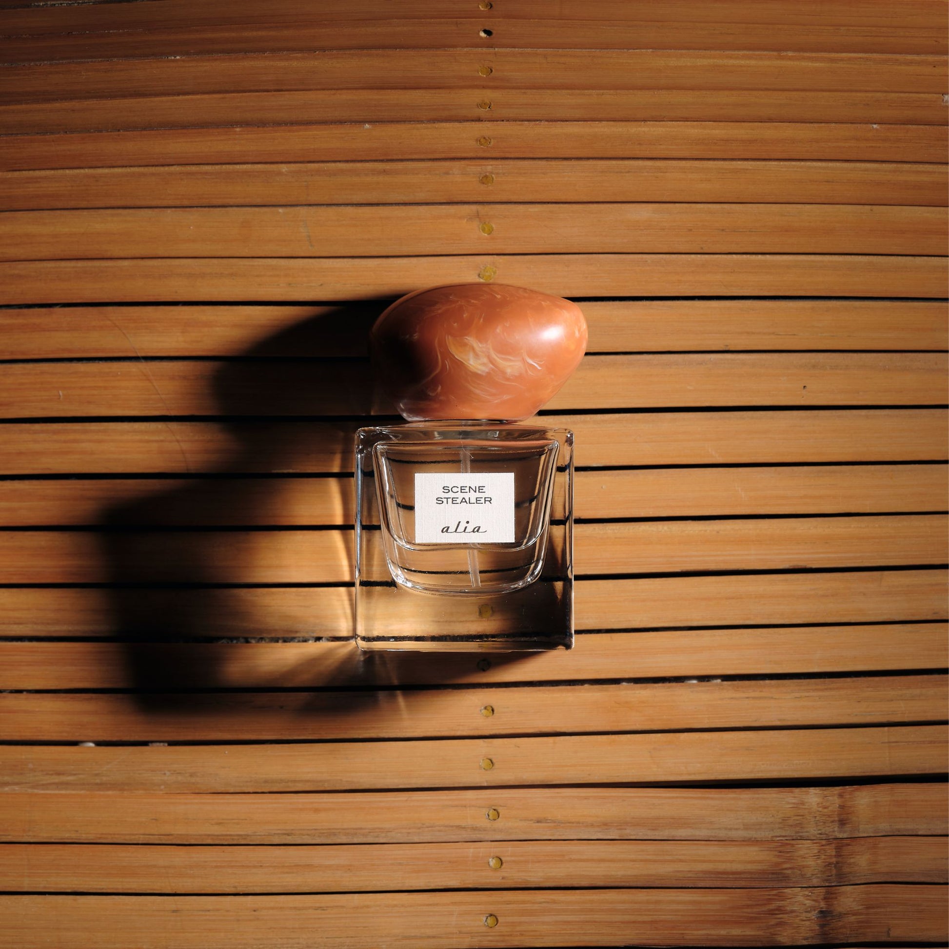 Alia Scene Stealer perfume bottle on a wooden surface
